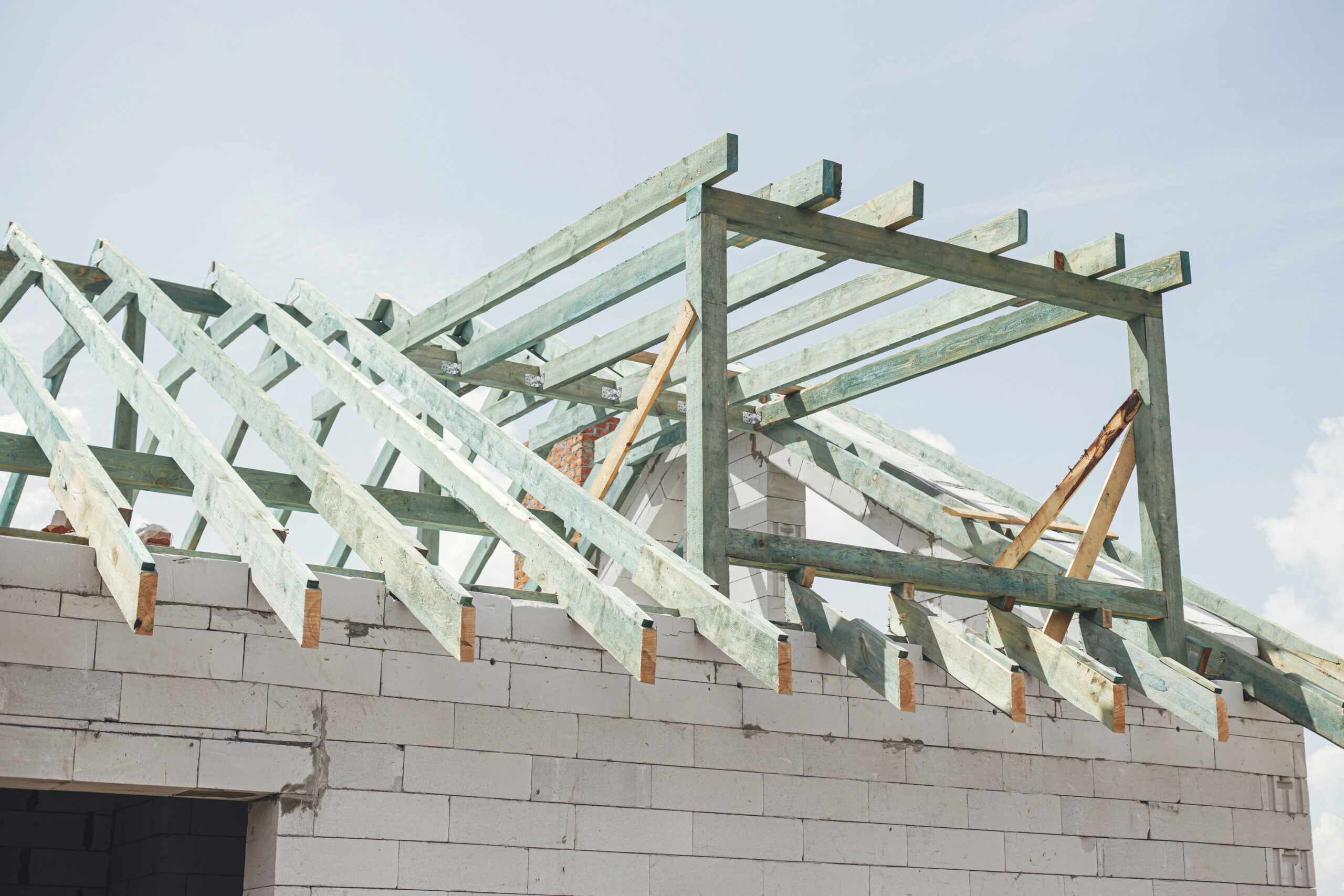 Unfinished modern farmhouse building. Wooden roof framing of man